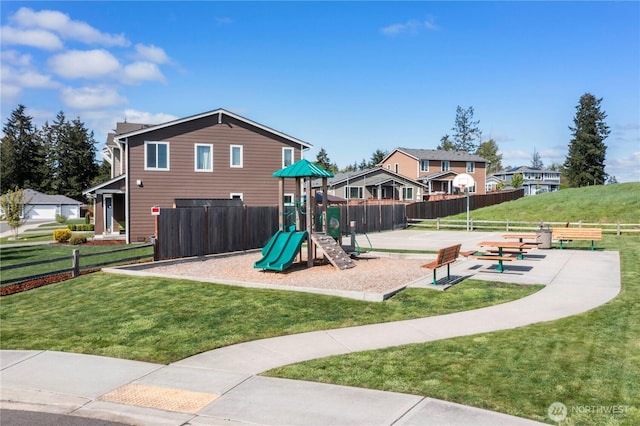 view of jungle gym with a lawn and fence