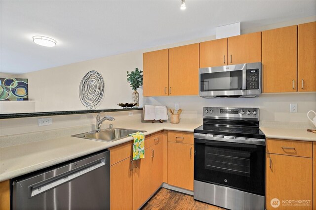 107 20th Ave Unit 306, Seattle, WA 98122 - kitchen featuring appliances with stainless steel finishes, a sink, light countertops, and wood finished floors