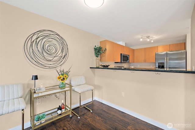107 20th Ave Unit 306, Seattle, WA 98122 - kitchen with stainless steel appliances, dark wood finished floors, dark countertops, and baseboards