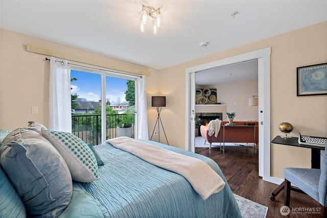 107 20th Ave Unit 306, Seattle, WA 98122 - bedroom featuring access to outside, wood finished floors, a lit fireplace, and baseboards