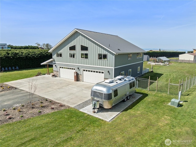 view of front of property featuring fence, concrete driveway, board and batten siding, a front yard, and a garage