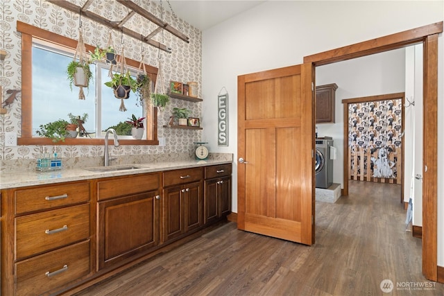 kitchen featuring open shelves, washer and dryer, a sink, and dark wood-style flooring