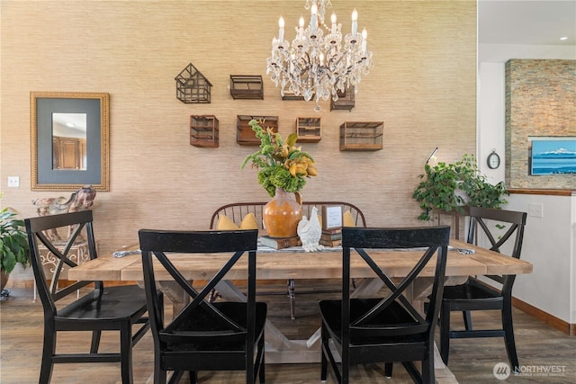 dining space featuring baseboards, wood finished floors, and a chandelier