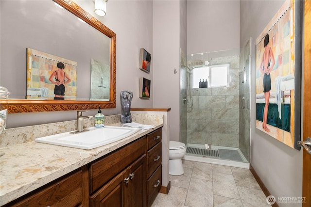 full bathroom featuring baseboards, vanity, a shower stall, and toilet