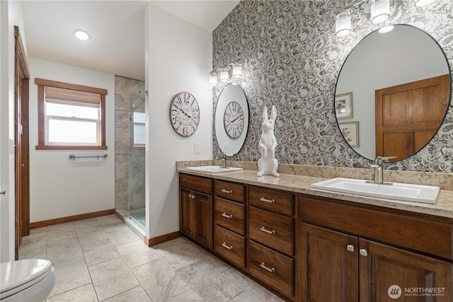full bath featuring wallpapered walls, a sink, and a tile shower