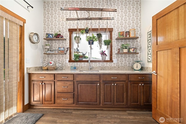interior space with open shelves, wallpapered walls, dark wood-style floors, and a sink