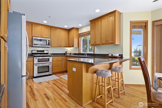 664 Lactrup Spur Ln, Camano Island, WA 98282 - kitchen with light wood-type flooring, a sink, a breakfast bar, stainless steel appliances, and recessed lighting