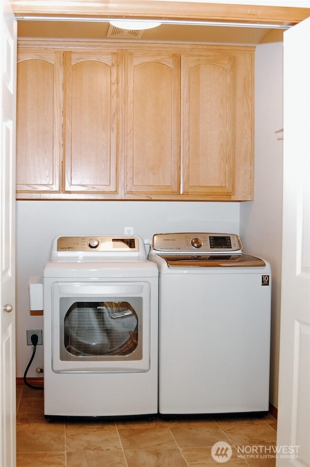 664 Lactrup Spur Ln, Camano Island, WA 98282 - laundry area featuring washing machine and clothes dryer, light tile patterned floors, and cabinet space
