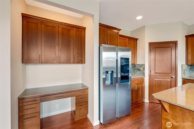 kitchen with stainless steel fridge with ice dispenser, light stone countertops, dark wood finished floors, brown cabinets, and recessed lighting