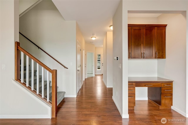 corridor featuring dark wood-type flooring, stairs, and baseboards