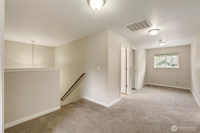 carpeted empty room featuring baseboards
