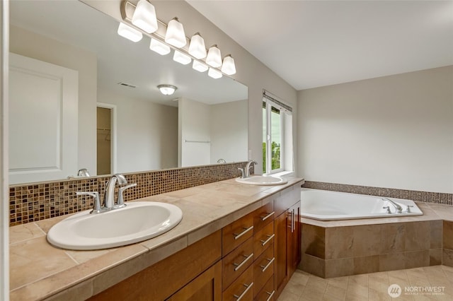 bathroom featuring a garden tub, double vanity, and tile patterned flooring