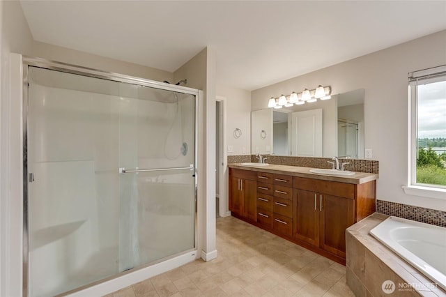bathroom with a shower stall, double vanity, and a bath