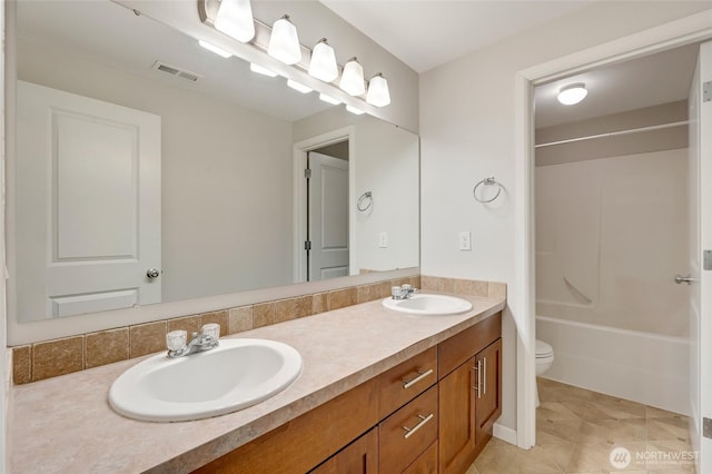 bathroom featuring double vanity, toilet, tile patterned flooring, and tub / shower combination