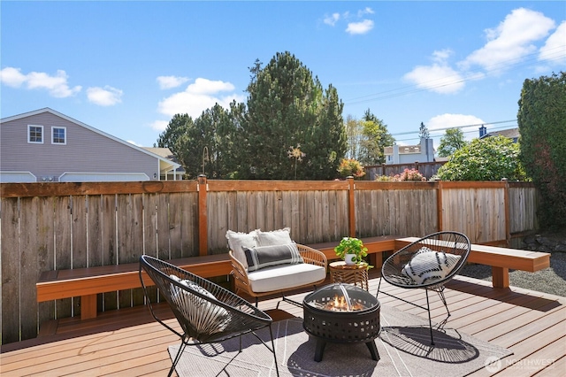 wooden terrace featuring an outdoor fire pit and fence