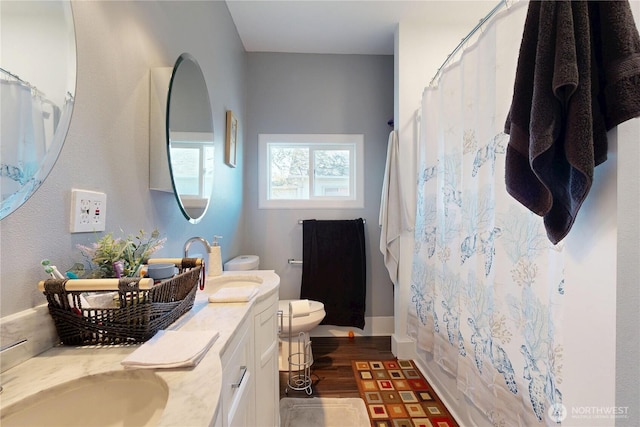 138 SE 5th Ave, Milton-Freewater, OR 97862 - bathroom with toilet, curtained shower, double vanity, and wood finished floors