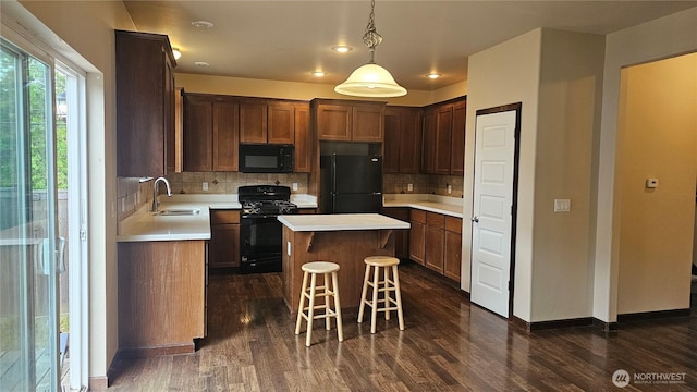 704 7th Ave SW, Tumwater, WA 98512 - kitchen with black appliances, a sink, dark wood-style floors, backsplash, and a kitchen island