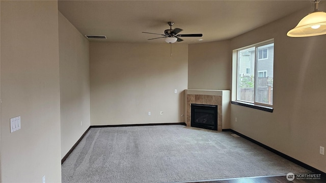704 7th Ave SW, Tumwater, WA 98512 - unfurnished living room featuring a ceiling fan, a fireplace, baseboards, and carpet flooring