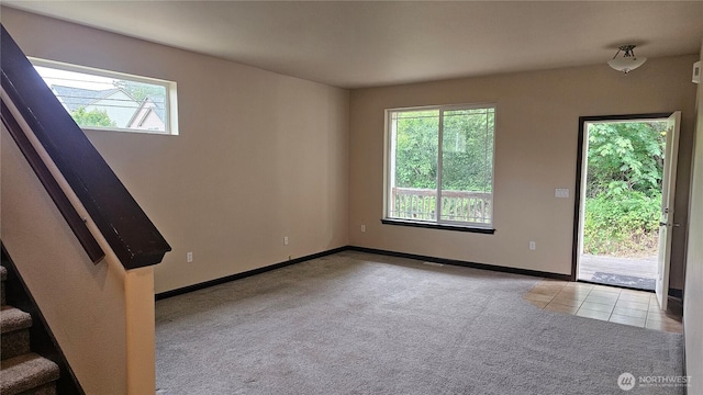 704 7th Ave SW, Tumwater, WA 98512 - empty room featuring plenty of natural light, carpet floors, tile patterned flooring, and baseboards