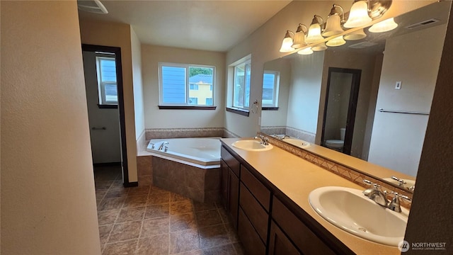704 7th Ave SW, Tumwater, WA 98512 - bathroom with toilet, a bath, a chandelier, and double vanity