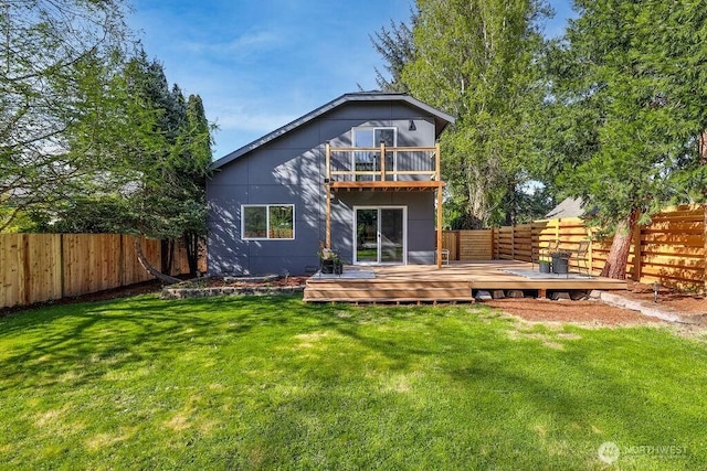 rear view of property with a fenced backyard, a balcony, a yard, and a deck