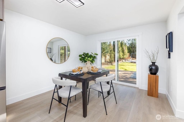 dining room featuring light wood-type flooring and baseboards