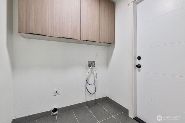 laundry area with hookup for an electric dryer, baseboards, dark tile patterned flooring, cabinet space, and washer hookup
