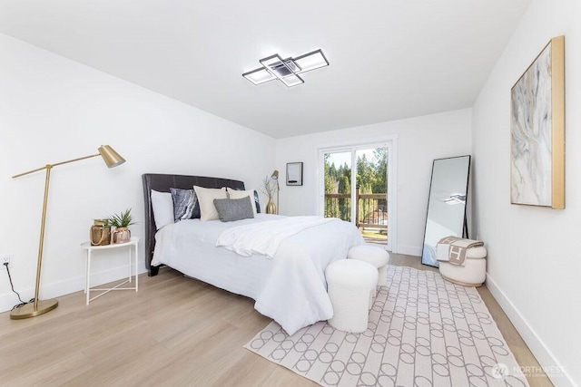 bedroom featuring baseboards, access to outside, and light wood-style floors