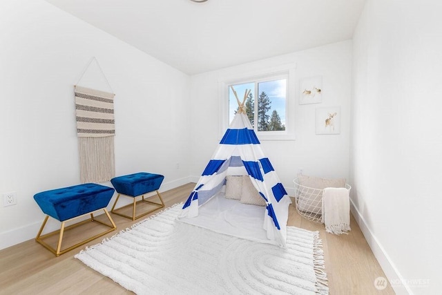 playroom featuring baseboards and wood finished floors