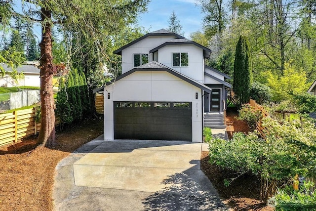view of front of house with concrete driveway and fence