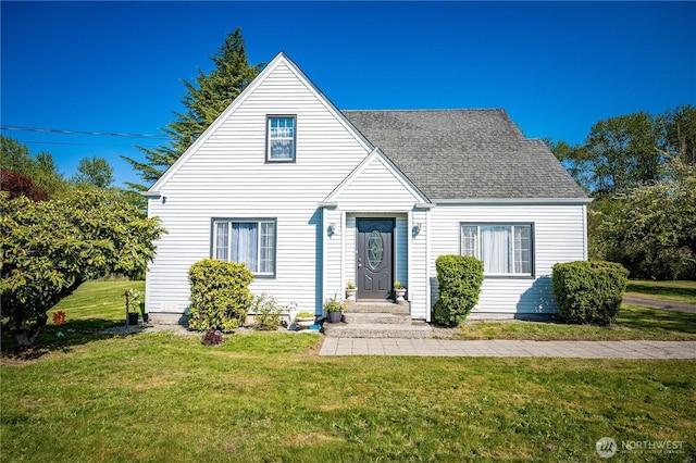 view of front of home with roof with shingles and a front lawn