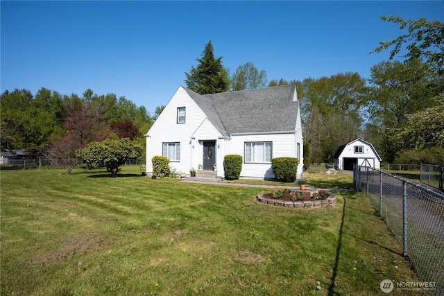 view of front of property with a front yard, an outbuilding, a detached garage, fence, and a shingled roof