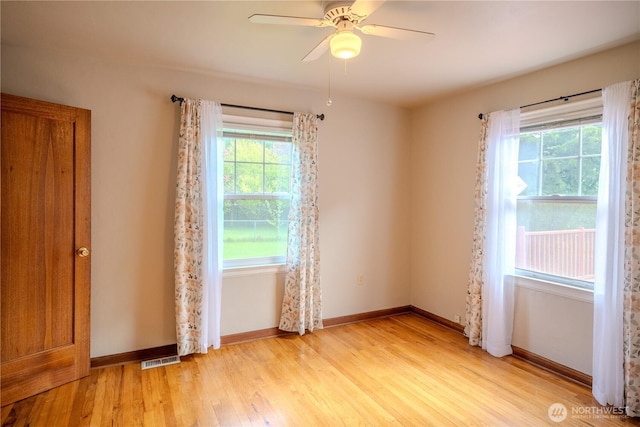 empty room with ceiling fan, visible vents, a healthy amount of sunlight, and light wood-style floors