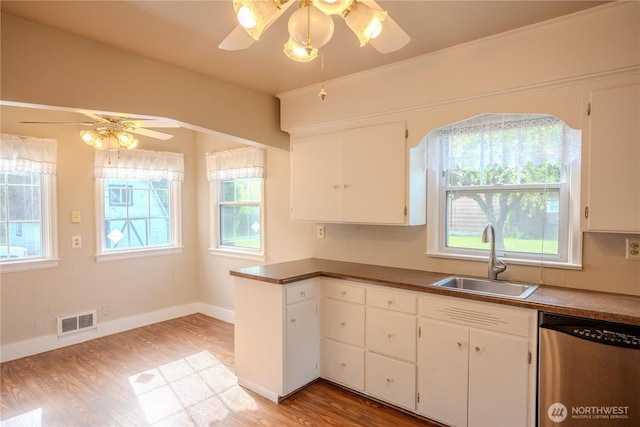 kitchen featuring ceiling fan, visible vents, dishwasher, a sink, and light wood finished floors