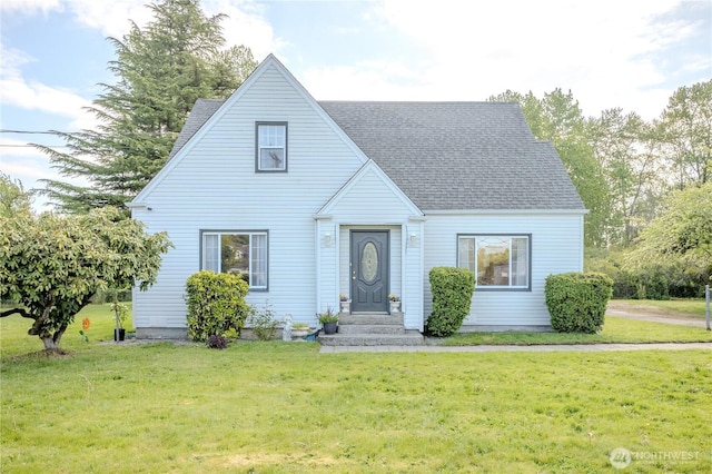 view of front facade featuring a shingled roof and a front yard