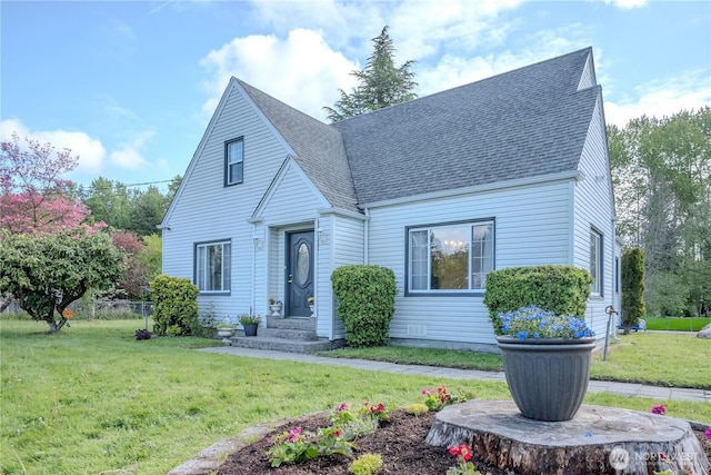 view of front facade featuring a shingled roof and a front yard