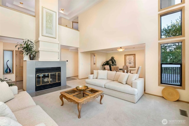 living room featuring a high ceiling and a tiled fireplace