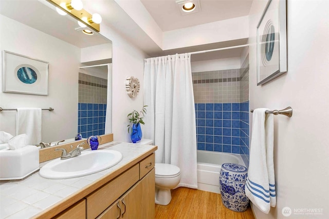 full bathroom featuring wood finished floors, toilet, vanity, and shower / bathtub combination with curtain
