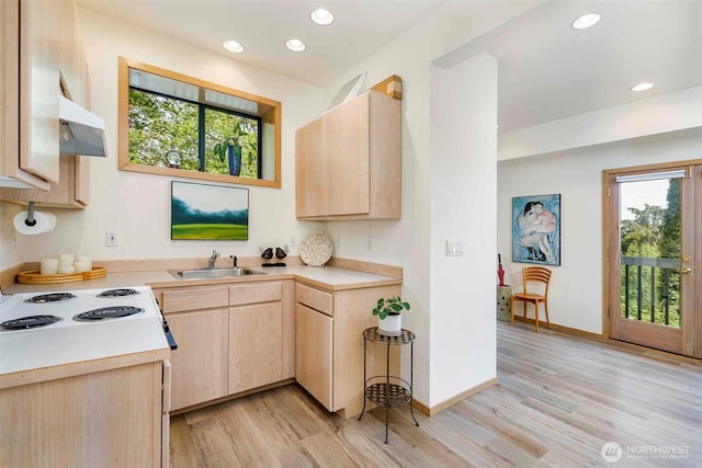 kitchen with light brown cabinets, a sink, light countertops, plenty of natural light, and recessed lighting