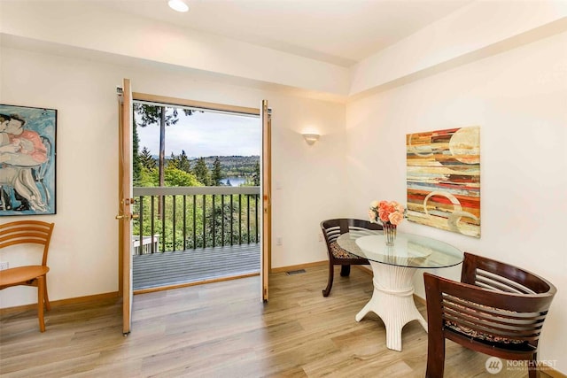 dining space featuring light wood-style flooring and baseboards