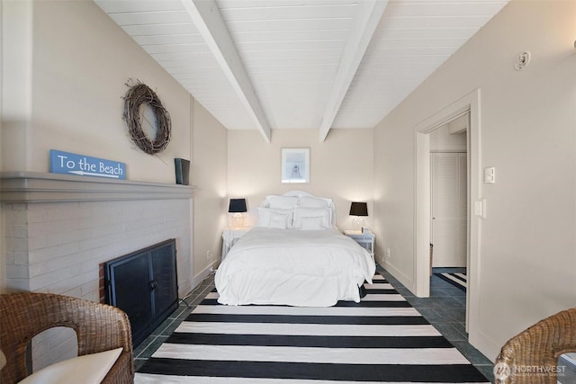 250 Fay Ln, Camano Island, WA 98282 - bedroom featuring baseboards, a fireplace, tile patterned floors, and beam ceiling