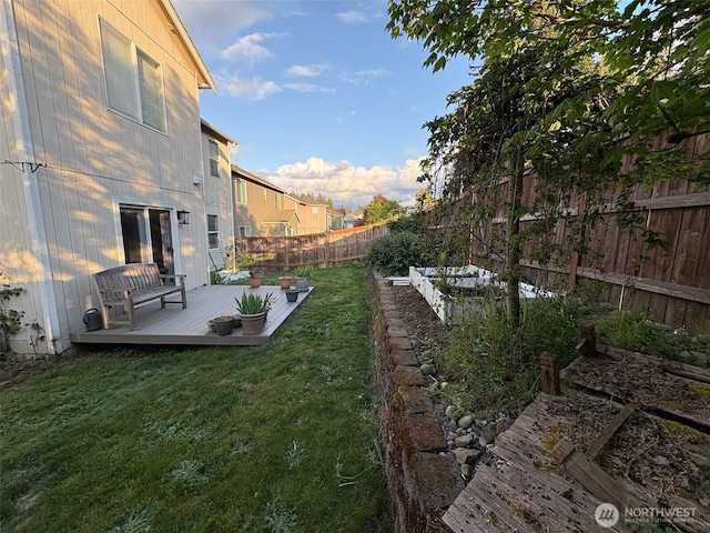 view of yard featuring a fenced backyard, a deck, and a vegetable garden
