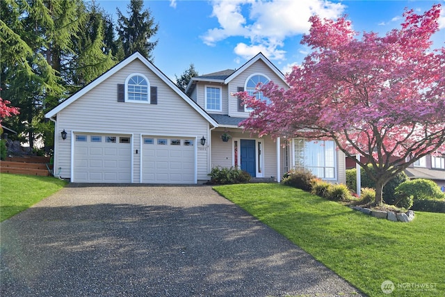traditional home featuring a garage, driveway, and a front yard