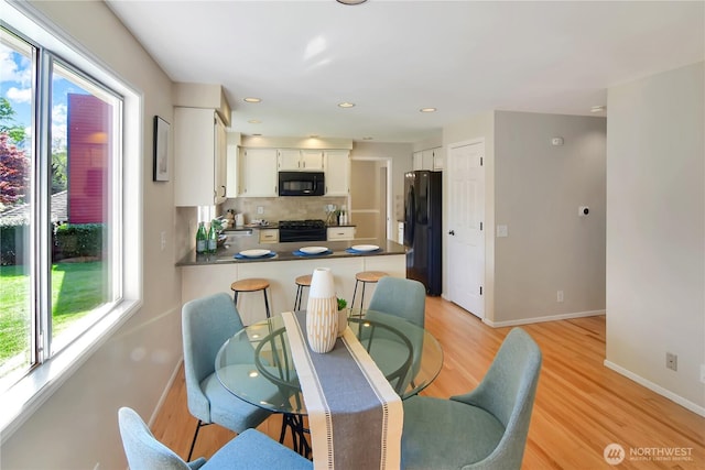 dining area featuring recessed lighting, baseboards, a wealth of natural light, and light wood-type flooring