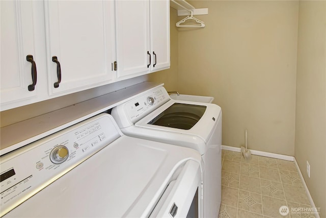 laundry area featuring cabinet space, baseboards, washing machine and dryer, and a sink