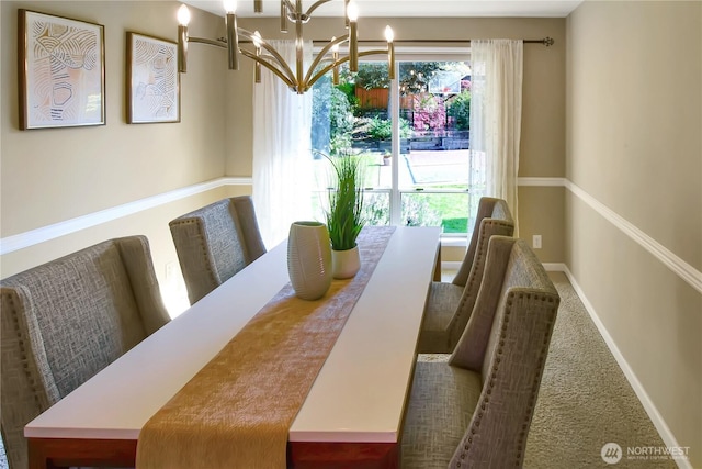 dining room with carpet floors, baseboards, and a chandelier