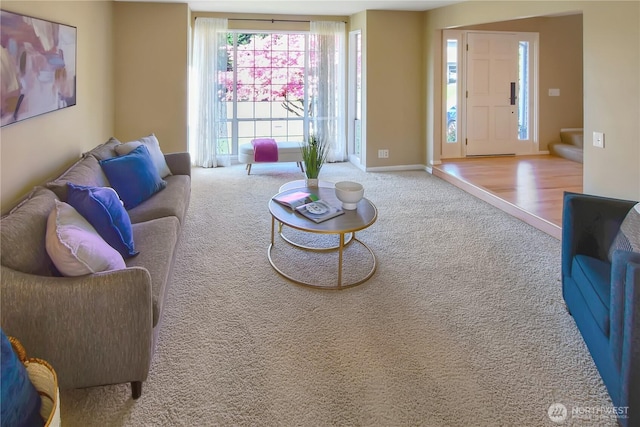 carpeted living area featuring baseboards