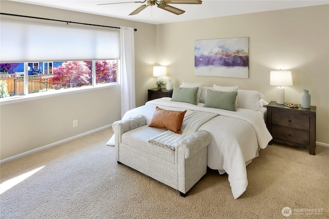 bedroom with a ceiling fan, baseboards, and light carpet