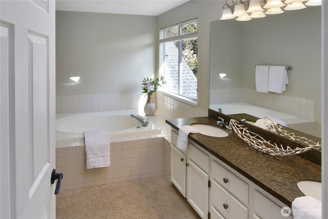 bathroom featuring double vanity, a sink, a bath, and an inviting chandelier