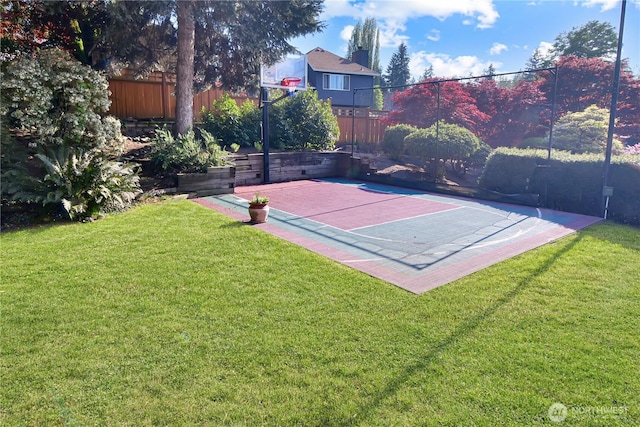view of sport court with basketball court, a lawn, and fence